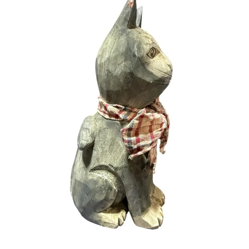 hand-carved‎ wooden cat figurine with a painted finish and a plaid cloth scarf.